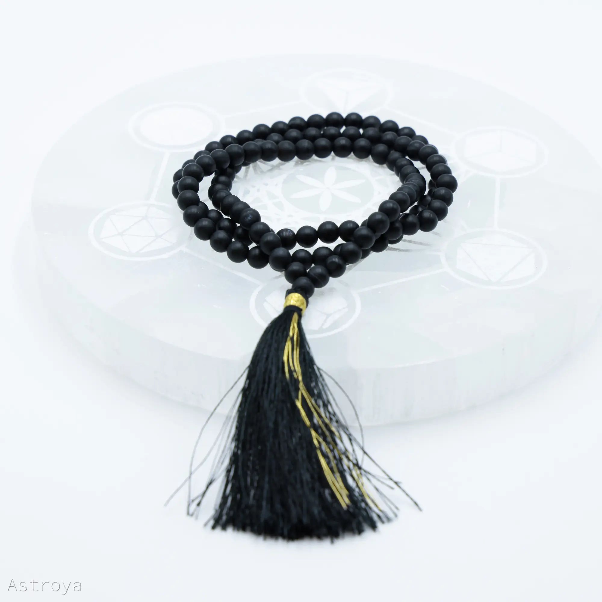 Mala Onyx Noir Mat sur une pierre de chargement en sélénite disponible également sur astroya.fr